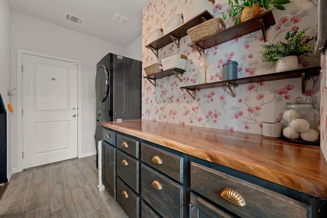 kitchen with open shelves, butcher block counters, light wood finished floors, baseboards, and visible vents