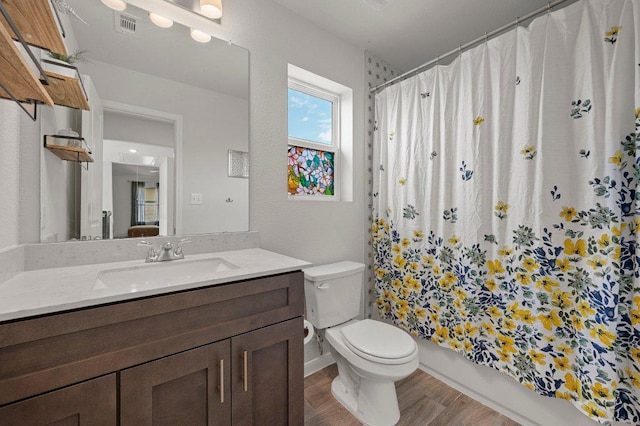 full bath with wood finished floors, vanity, visible vents, toilet, and shower / bath combo with shower curtain