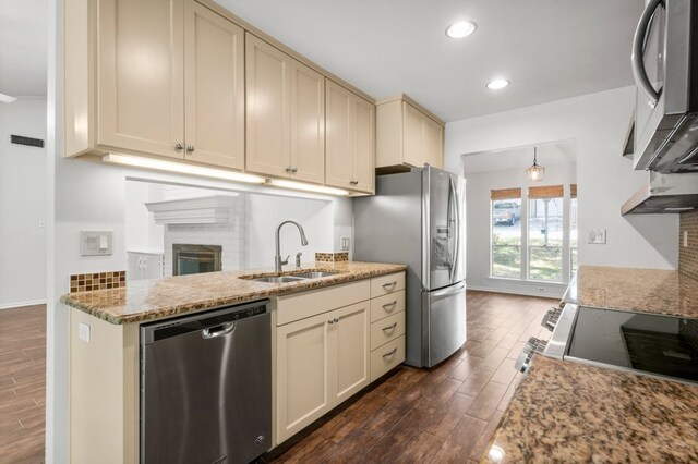 11525 Spring Hill Dr, Austin, TX 78753 - kitchen with appliances with stainless steel finishes, dark wood-style flooring, a sink, cream cabinets, and light stone countertops