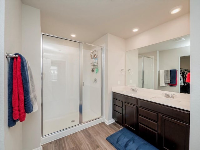369 Empress Tree Dr, Leander, TX 78641 - bathroom with wood finished floors, a shower stall, double vanity, recessed lighting, and a spacious closet