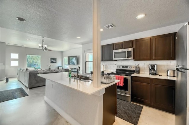 1302 E 3rd St, Austin, TX 78702 - kitchen featuring appliances with stainless steel finishes, decorative backsplash, light countertops, a textured ceiling, and dark brown cabinetry