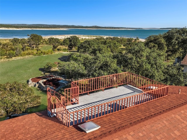 wooden deck featuring a lawn and a water view