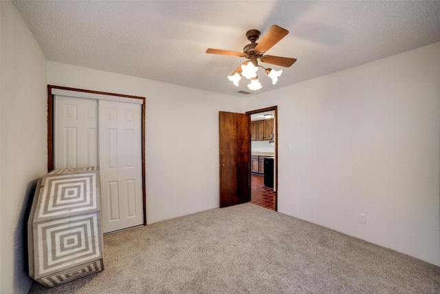 unfurnished bedroom with ceiling fan, carpet flooring, and a closet