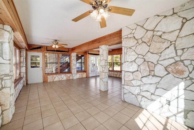 unfurnished living room featuring decorative columns, ceiling fan, and light tile patterned flooring