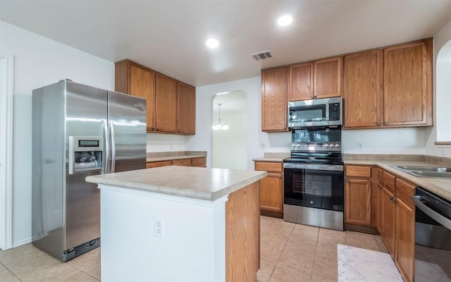 504 Dark Tree Ln, Round Rock, TX 78664 - kitchen with appliances with stainless steel finishes, arched walkways, light countertops, and brown cabinets