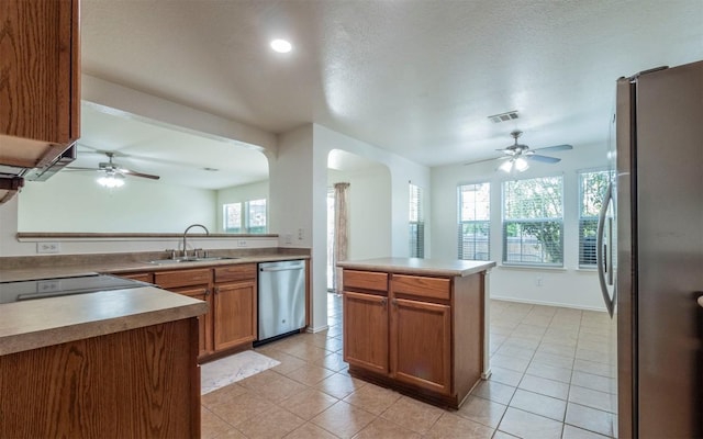 504 Dark Tree Ln, Round Rock, TX 78664 - kitchen featuring stainless steel appliances, ceiling fan, brown cabinetry, light tile patterned floors, and recessed lighting