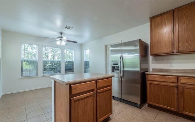 504 Dark Tree Ln, Round Rock, TX 78664 - kitchen featuring stainless steel fridge, ceiling fan, brown cabinets, and light tile patterned floors