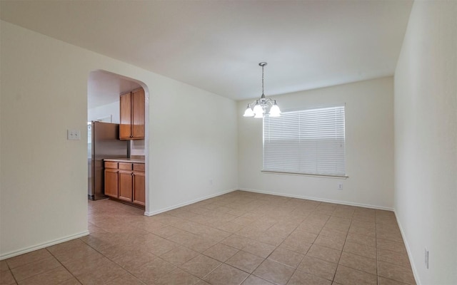 504 Dark Tree Ln, Round Rock, TX 78664 - unfurnished room with a chandelier, arched walkways, and light tile patterned flooring