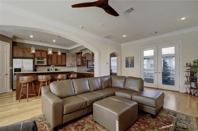 1621 Enfield Rd Unit B, Austin, TX 78703 - living room with french doors, light wood finished floors, arched walkways, a ceiling fan, and crown molding