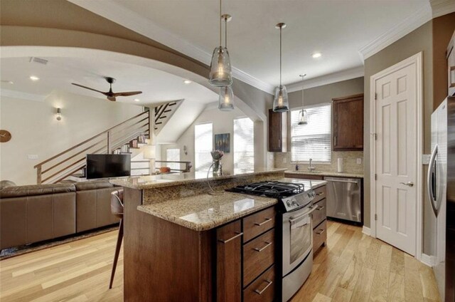 1621 Enfield Rd Unit B, Austin, TX 78703 - kitchen featuring appliances with stainless steel finishes, open floor plan, a kitchen breakfast bar, light wood-style floors, and crown molding