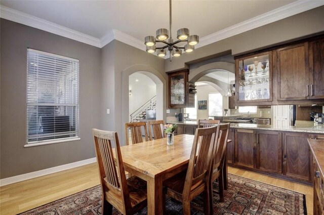 1621 Enfield Rd Unit B, Austin, TX 78703 - dining room with arched walkways, light wood-type flooring, a chandelier, ornamental molding, and stairs