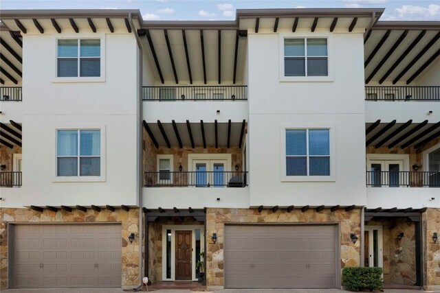1621 Enfield Rd Unit B, Austin, TX 78703 - townhome / multi-family property with stone siding, a balcony, an attached garage, and stucco siding