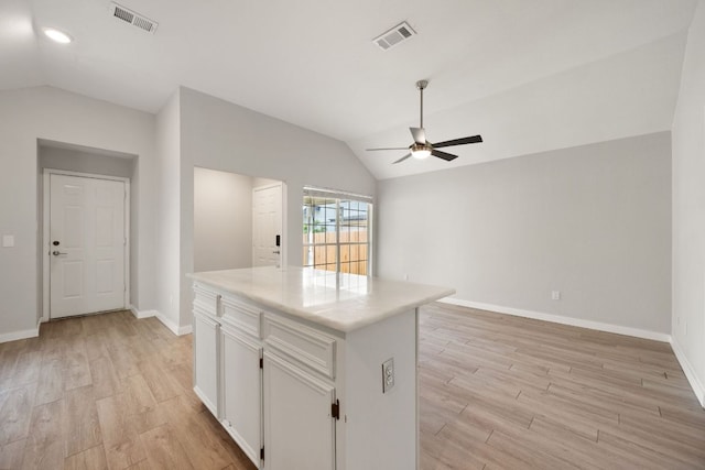 kitchen with light wood finished floors, vaulted ceiling, visible vents, and ceiling fan