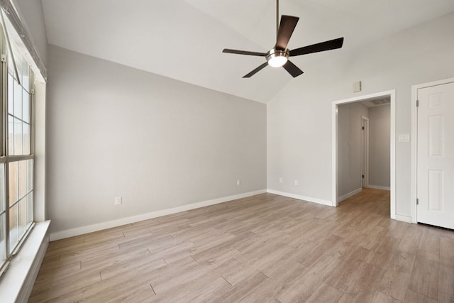 unfurnished room featuring baseboards, lofted ceiling, a ceiling fan, and light wood-style flooring