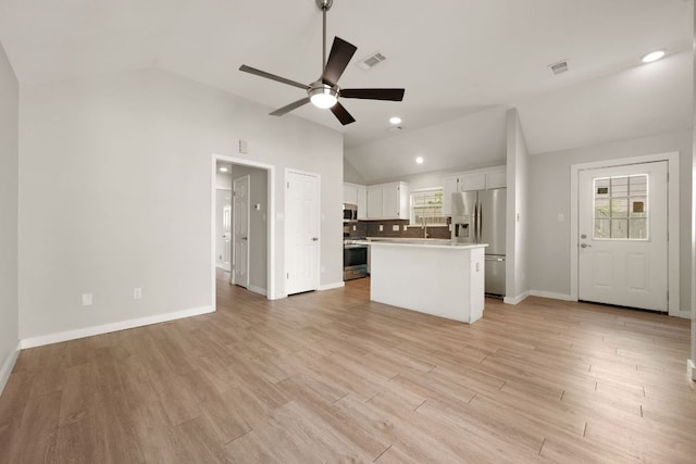 unfurnished living room with lofted ceiling, visible vents, a ceiling fan, and baseboards