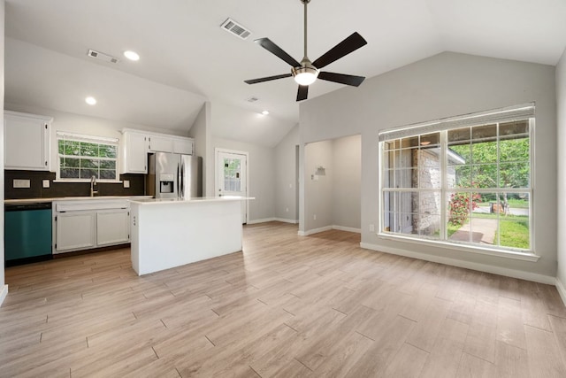 kitchen featuring white cabinets, vaulted ceiling, visible vents, dishwashing machine, and stainless steel refrigerator with ice dispenser