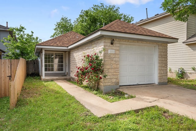 view of front of home featuring driveway, stone siding, fence, a garage, and roof with shingles