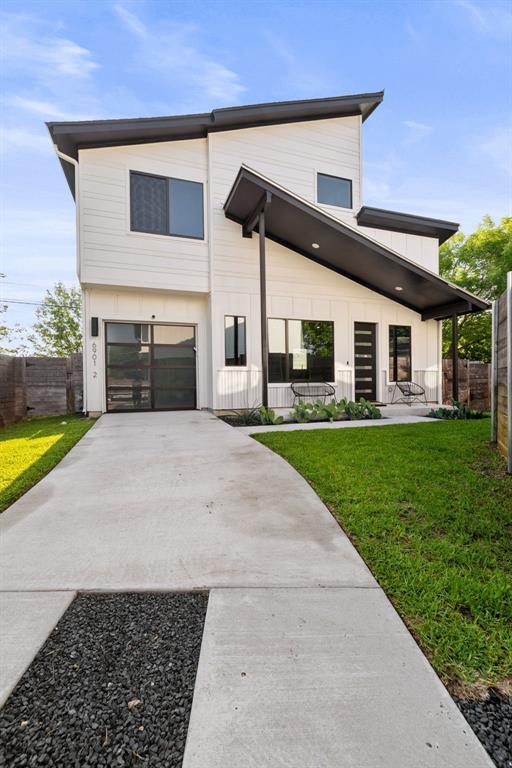 view of front of property with an attached garage, a front yard, concrete driveway, and fence
