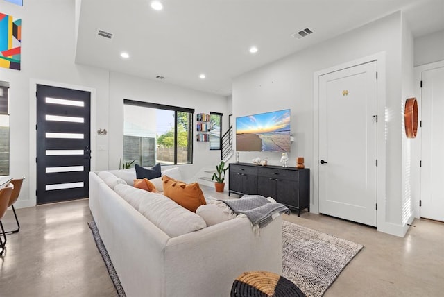 living room featuring concrete flooring, visible vents, baseboards, and recessed lighting
