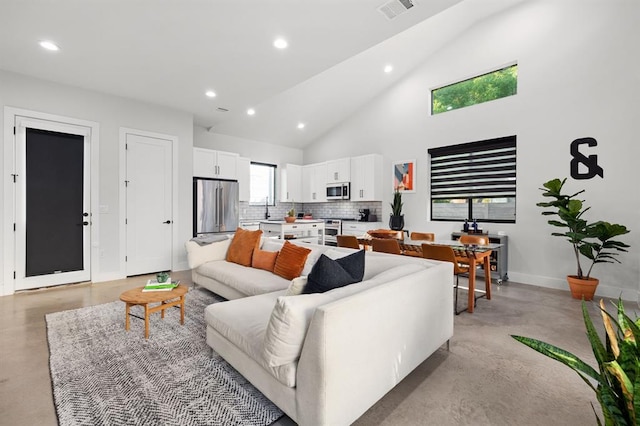 living area with recessed lighting, visible vents, baseboards, finished concrete floors, and high vaulted ceiling