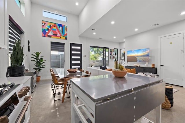 kitchen with concrete floors, white range with gas cooktop, visible vents, and recessed lighting