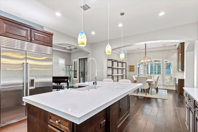 205 Bisset Ct, Austin, TX 78738 - kitchen featuring built in fridge, arched walkways, light countertops, dark wood-style floors, and recessed lighting