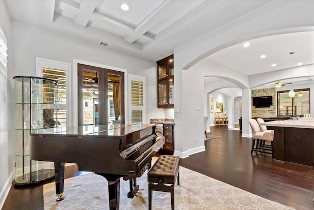 205 Bisset Ct, Austin, TX 78738 - sitting room with arched walkways, recessed lighting, dark wood finished floors, ceiling fan, and beamed ceiling