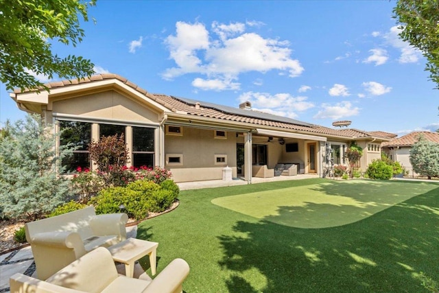 205 Bisset Ct, Austin, TX 78738 - back of property featuring a putting green, roof mounted solar panels, an outdoor living space, and a tile roof