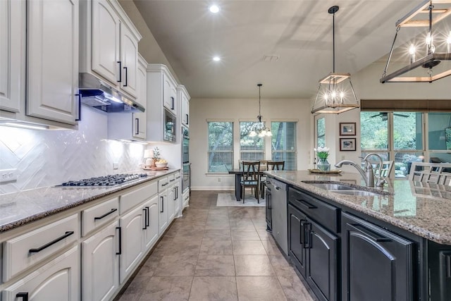 29047 Hobblebush, San Antonio, TX 78260 - kitchen with stainless steel appliances, under cabinet range hood, white cabinetry, a chandelier, and decorative backsplash