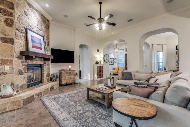 29047 Hobblebush, San Antonio, TX 78260 - living area featuring ceiling fan, crown molding, a stone fireplace, and arched walkways