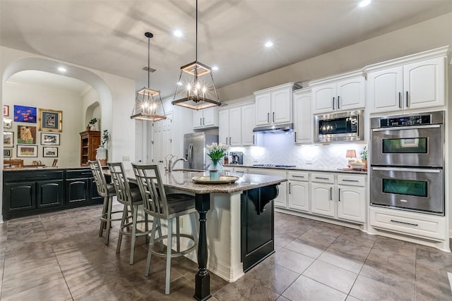 29047 Hobblebush, San Antonio, TX 78260 - kitchen with appliances with stainless steel finishes, arched walkways, white cabinets, decorative backsplash, and recessed lighting