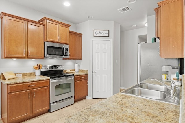 19000 Obed River Dr, Pflugerville, TX 78660 - kitchen featuring a sink, light tile patterned flooring, stainless steel appliances, light countertops, and visible vents