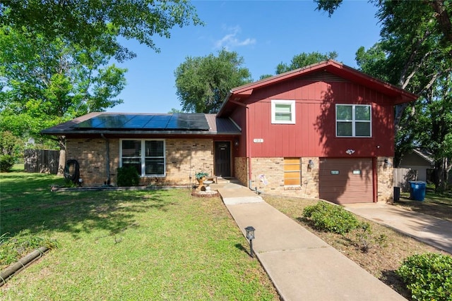 1212 Lake Terrace Dr, Elgin, TX 78621 - tri-level home with roof mounted solar panels, driveway, brick siding, and a garage
