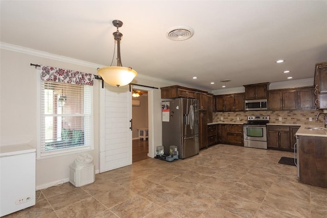 1212 Lake Terrace Dr, Elgin, TX 78621 - kitchen featuring crown molding, tasteful backsplash, a sink, light countertops, and appliances with stainless steel finishes