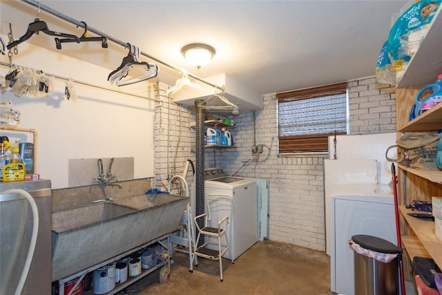 1212 Lake Terrace Dr, Elgin, TX 78621 - clothes washing area featuring washing machine and dryer, brick wall, and laundry area
