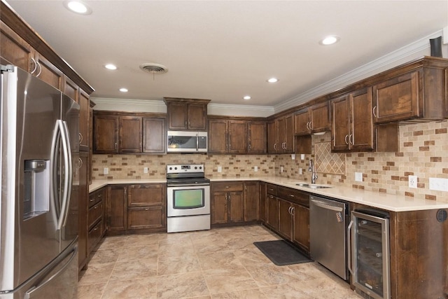 1212 Lake Terrace Dr, Elgin, TX 78621 - kitchen with dark brown cabinets, beverage cooler, crown molding, and stainless steel appliances
