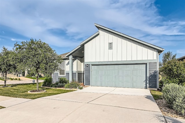 9945 Comely Bnd, Manor, TX 78653 - view of front facade with board and batten siding, driveway, and an attached garage