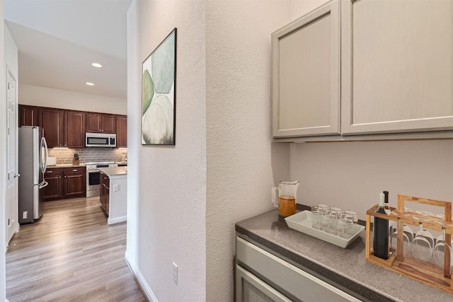 9945 Comely Bnd, Manor, TX 78653 - bar with stainless steel appliances, light wood-style floors, decorative backsplash, and recessed lighting