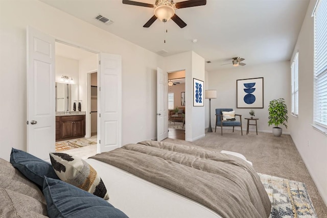 9945 Comely Bnd, Manor, TX 78653 - bedroom with multiple windows, light colored carpet, ensuite bathroom, and baseboards