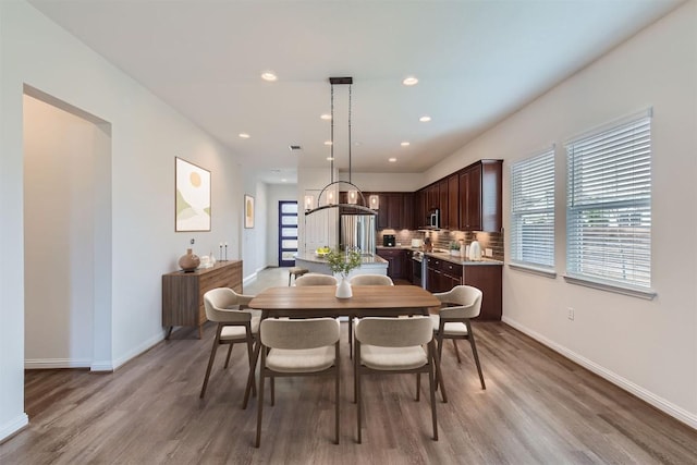 9945 Comely Bnd, Manor, TX 78653 - dining room featuring wood finished floors, baseboards, and recessed lighting