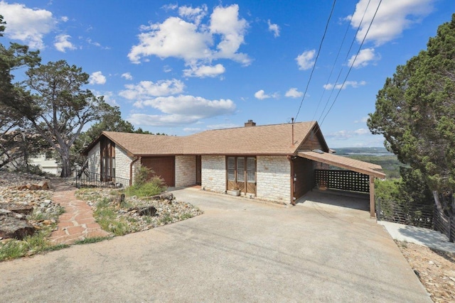 21009 Fawn Ridge Dr, Lago Vista, TX 78645 - view of front of house featuring a chimney, fence, driveway, an attached carport, and stone siding