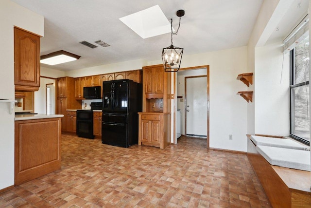21009 Fawn Ridge Dr, Lago Vista, TX 78645 - kitchen with a skylight, brown cabinetry, black appliances, a notable chandelier, and brick patterned floor