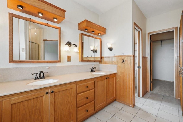 21009 Fawn Ridge Dr, Lago Vista, TX 78645 - bathroom featuring a wainscoted wall, a sink, a shower stall, and double vanity