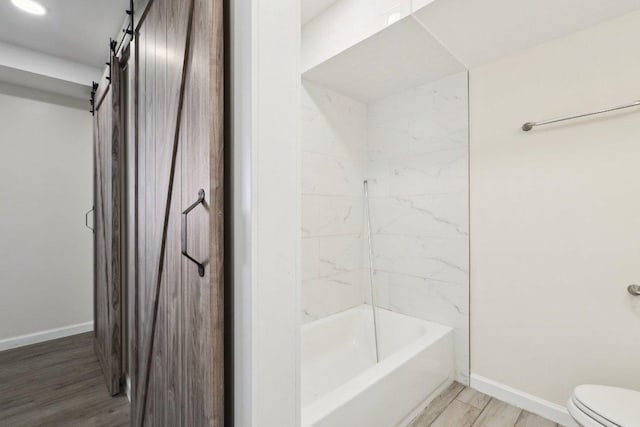 21009 Fawn Ridge Dr, Lago Vista, TX 78645 - bathroom featuring shower / bathing tub combination, wood finished floors, baseboards, and toilet