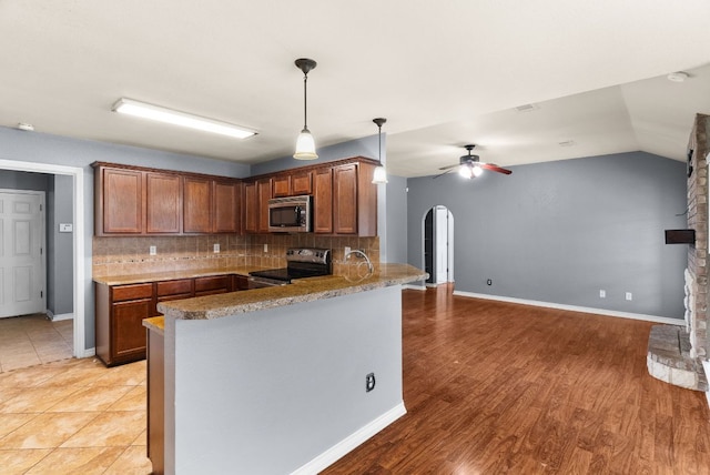 6060 County Road 3300, Kempner, TX 76539 - kitchen featuring a ceiling fan, arched walkways, backsplash, a peninsula, and appliances with stainless steel finishes