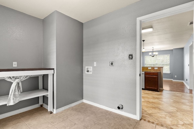 6060 County Road 3300, Kempner, TX 76539 - clothes washing area with hookup for an electric dryer, light tile patterned flooring, an inviting chandelier, laundry area, and washer hookup