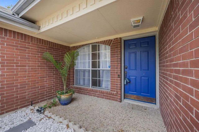 entrance to property featuring brick siding