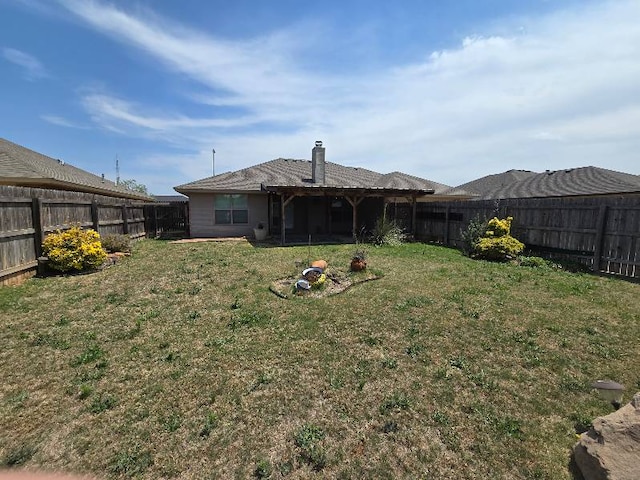 back of house featuring a fenced backyard and a yard