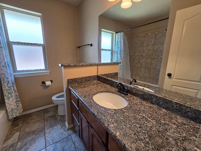 bathroom with baseboards, toilet, vanity, and plenty of natural light