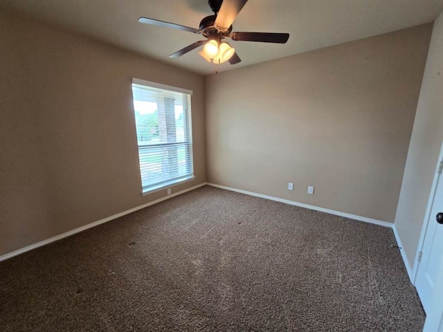 spare room featuring a ceiling fan, baseboards, and carpet
